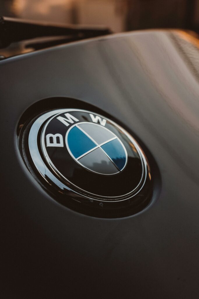Close-up of a shiny BMW logo on a luxury car, emphasizing modern design.